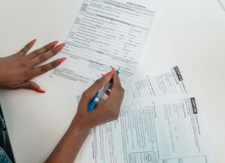 Czy jestem „wystarczająco chory” by starać się o orzeczenie obalamy mity Kobieta o czerwonych paznokciach wypełnia formularz przy biurku